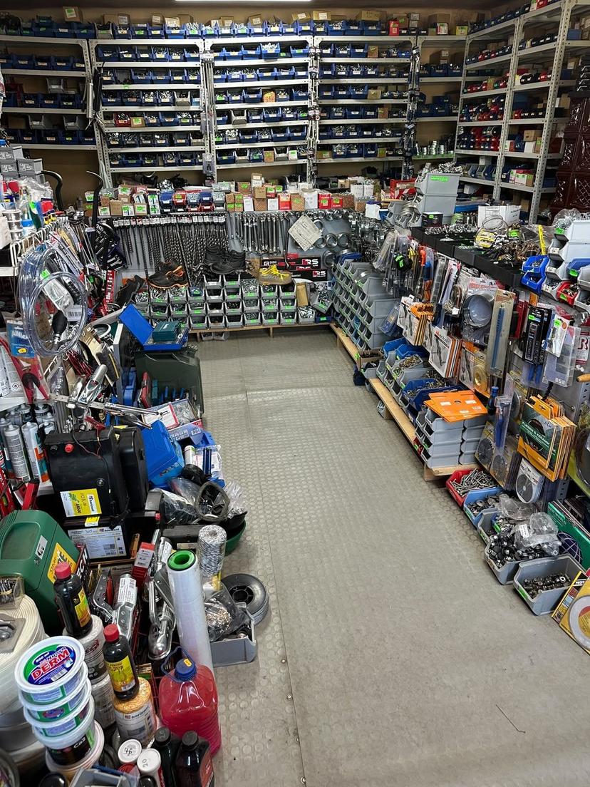 Rafturi cu cutii de șuruburi, piulițe și șaibe în magazinul din Beiuș